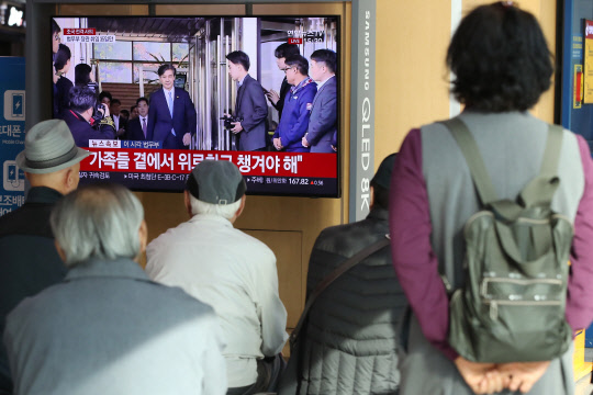 결국…    14일 서울역 대합실에서 시민들이 사의를 밝힌 후 법무부를 나서는 조국 법무부 장관의 모습을 뉴스로 시청하고 있다.    연합뉴스